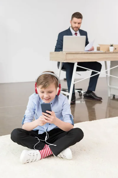 Het luisteren muziek jongen op kantoor — Gratis stockfoto