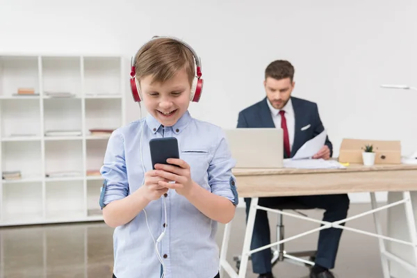 Мальчик слушает музыку в офисе — стоковое фото
