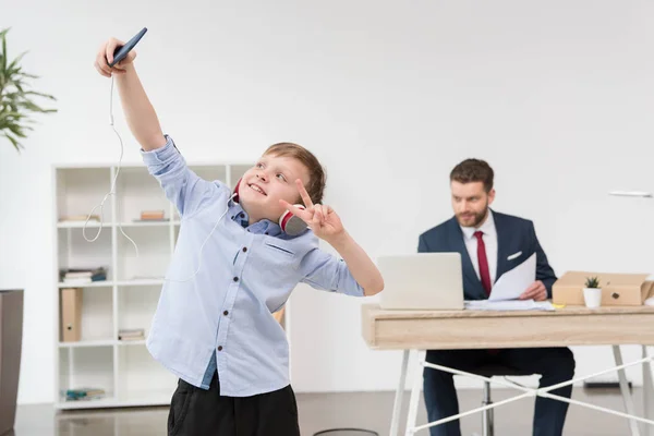 Boy taking self portrait at office — Stock Photo, Image