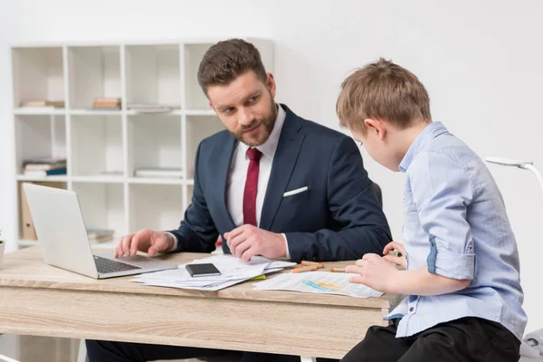 İşadamı oğlu iş kağıtları üzerinde çizim ile