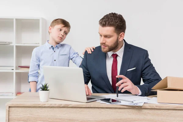 Stoute jongen met zijn vader zakenman — Stockfoto