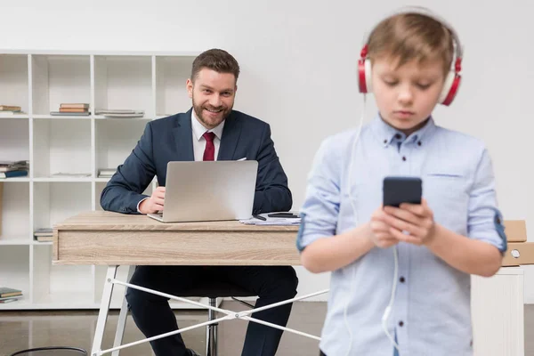 Entrepreneur at office with his son — Stock Photo, Image