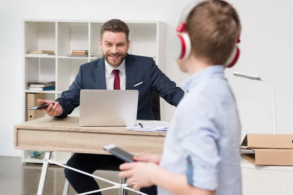 Entrepreneur at office with his son — Stock Photo, Image