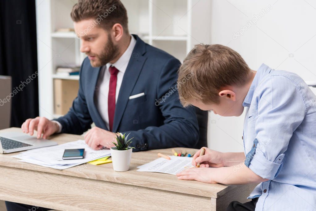 Businessman with son drawing on business papers