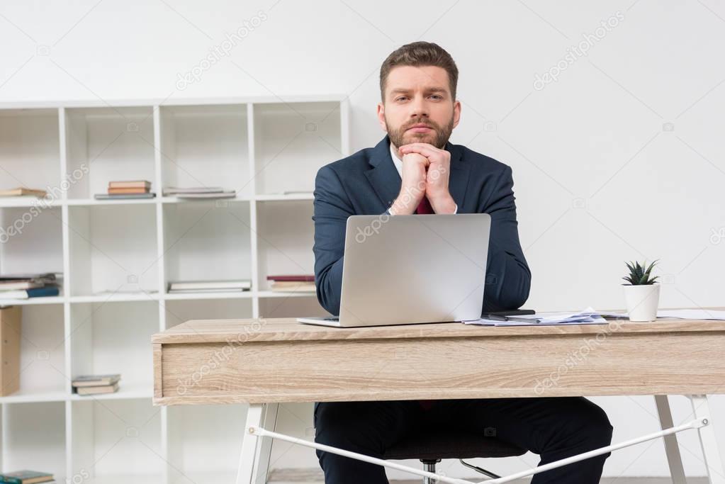 thoughtful businessman at table in office