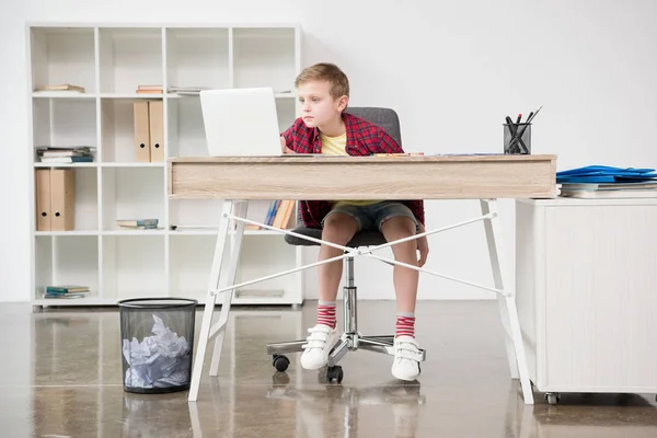 Школьник с помощью ноутбука в офисе — стоковое фото