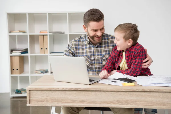 Freelance che lavora a tavola con figlio — Foto Stock