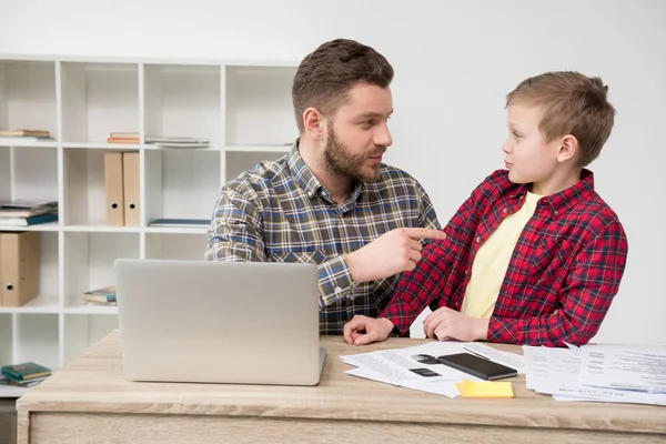 Freelancer trabajando en la mesa con su hijo —  Fotos de Stock