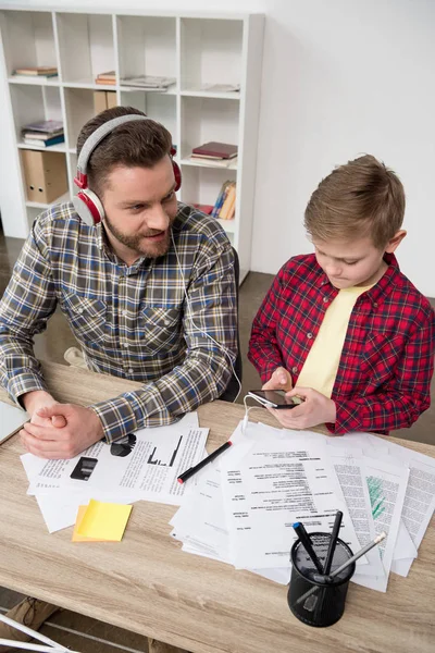 Businessman in headphones with son — Free Stock Photo