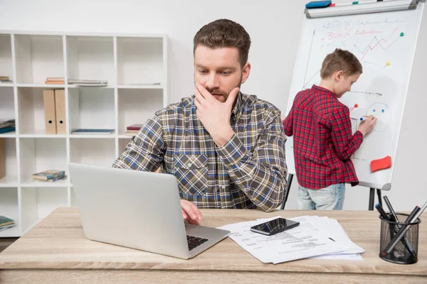 Freelancer med son på kontor — Stockfoto