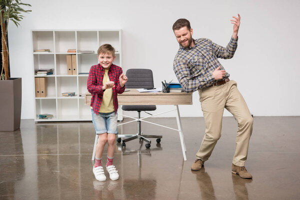 Businessman with son playing on imaginary guitar