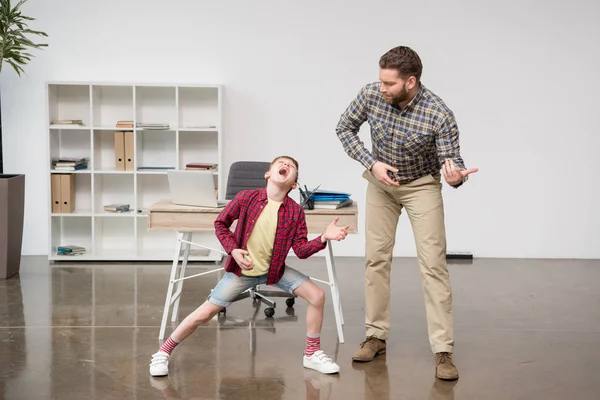 Zakenman met zoon spelen op denkbeeldige gitaar — Stockfoto