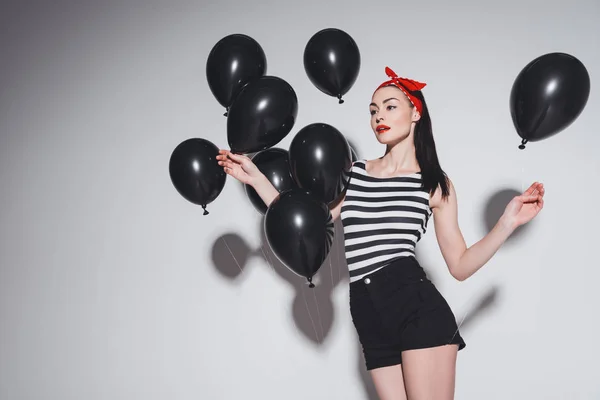 Stylish woman with black balloons — Stock Photo, Image