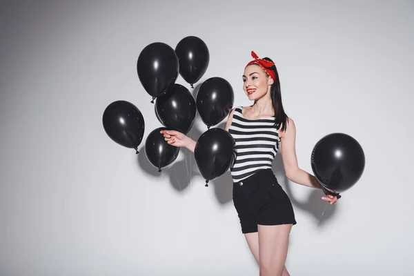 Snygg kvinna med svarta ballonger — Stockfoto