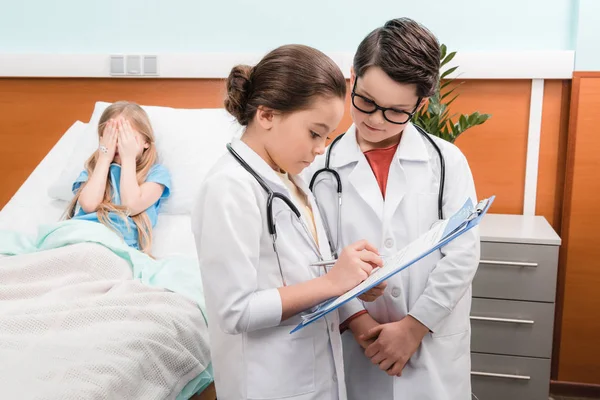 Enfants jouant les médecins et le patient — Photo de stock