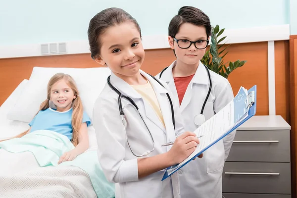Kids playing doctors and patient — Stock Photo