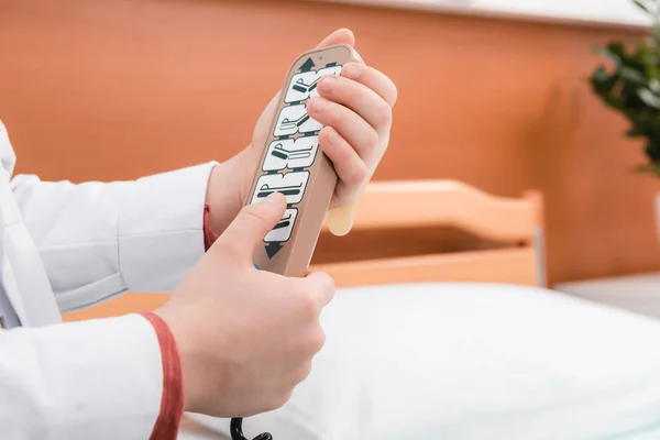 Menino médico com controle remoto da cama — Fotografia de Stock