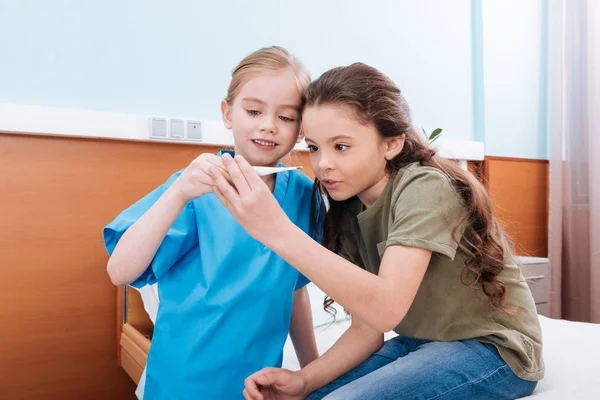 Niños jugando enfermera y paciente - foto de stock