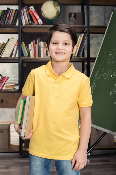 Schoolboy holding books — Stock Photo