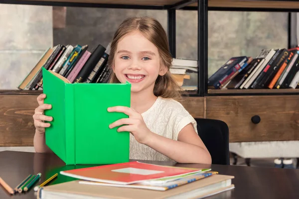 Schoolgirl studying in library — Stock Photo