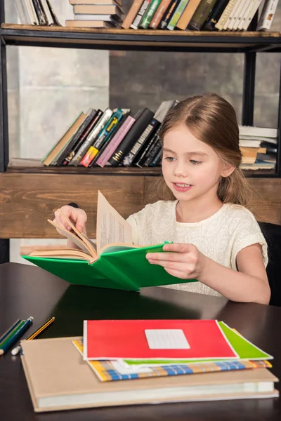 Schoolgirl studying in library — Stock Photo