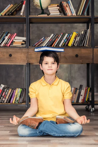 Garçon avec livre dans la bibliothèque — Photo de stock