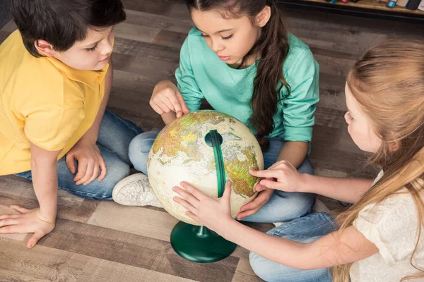 Enfants avec globe dans la bibliothèque — Photo de stock