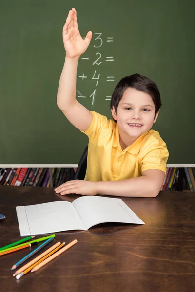 Niño sentado en la mesa en el aula - foto de stock