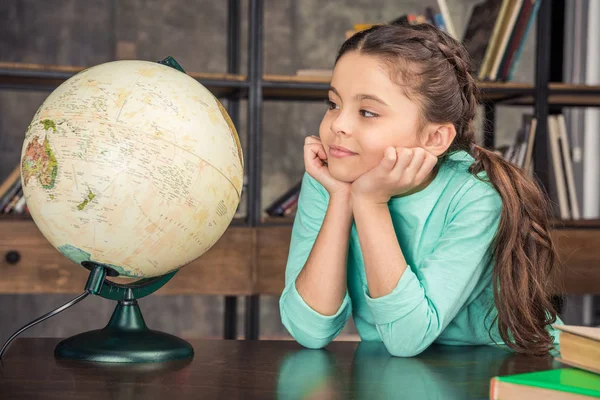 Mädchen mit Globus in Bibliothek — Stockfoto