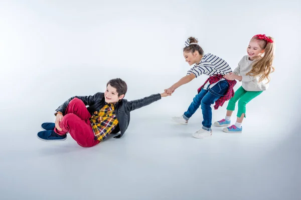 Meninas puxando menino — Fotografia de Stock