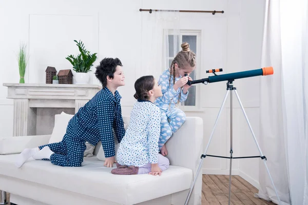 Дети играют с телескопом — стоковое фото