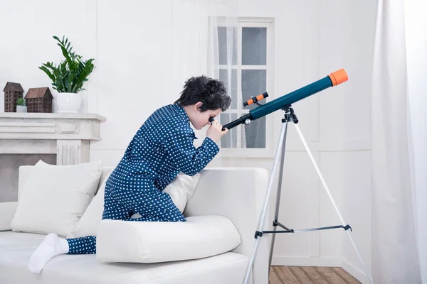 Kleiner Junge blickt durchs Teleskop — Stockfoto