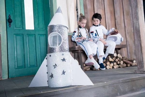 Cohete de juguete y astronautas niños - foto de stock