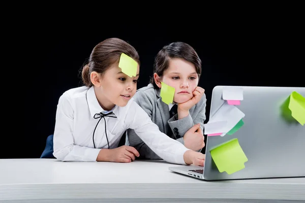 Niña y niño usando el ordenador portátil - foto de stock