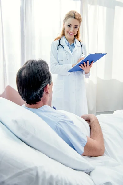 Paciente y médico con diagnóstico - foto de stock