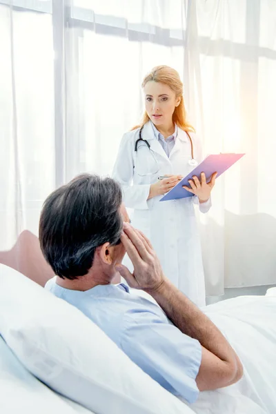 Patient and doctor with diagnosis — Stock Photo