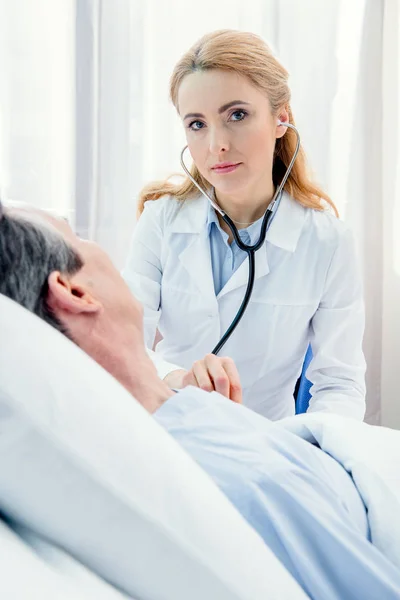 Doctor examining patient with stethoscope — Stock Photo