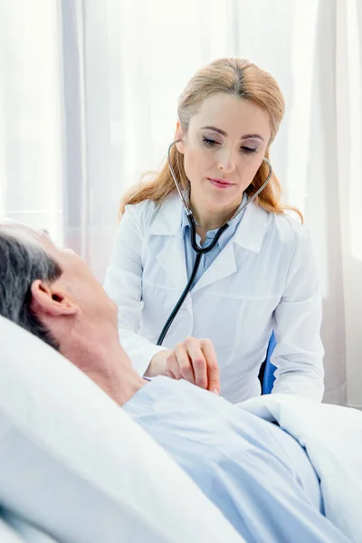 Doctor examining patient with stethoscope — Stock Photo