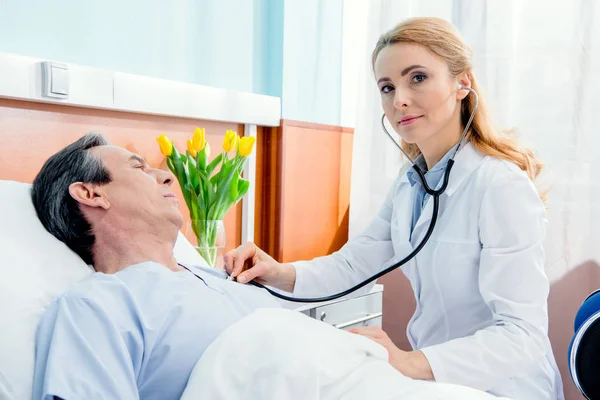 Doctor examining patient with stethoscope — Stock Photo