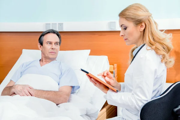 Patient et médecin avec tablette numérique — Photo de stock