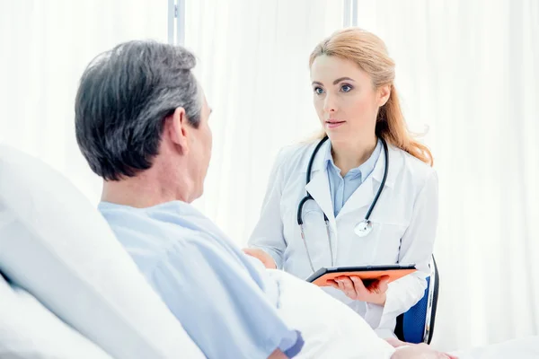 Paciente y médico con comprimido digital - foto de stock