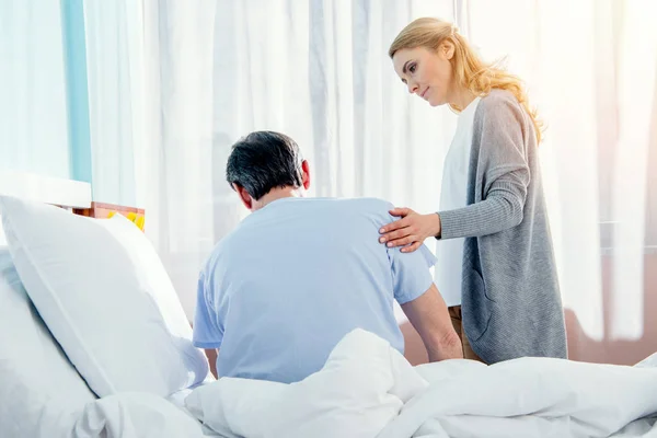 Woman helping husband stand up — Stock Photo