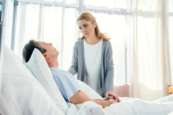 Esposa visitando marido en hospital - foto de stock