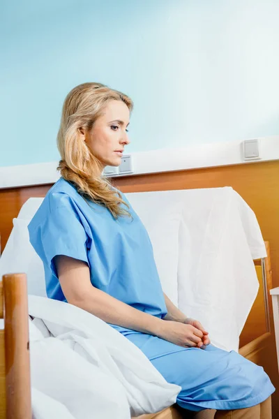 Woman sitting on hospital bed — Stock Photo