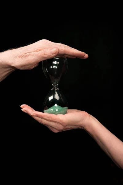 Senior couple holding hourglass — Stock Photo