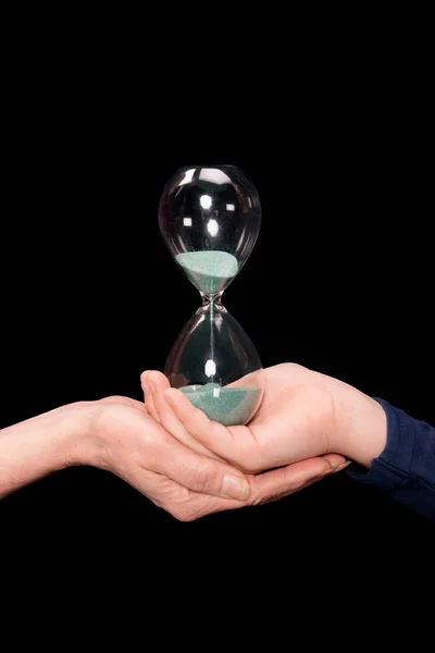 Grandchild and grandmother holding hourglass — Stock Photo