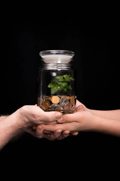 Großvater und Enkelin mit Münzen und Pflanze im Glas — Stockfoto