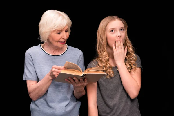 Grandmother and granddaughter with book — Stock Photo