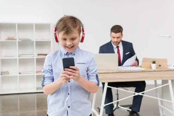 Boy listening music at office — Stock Photo