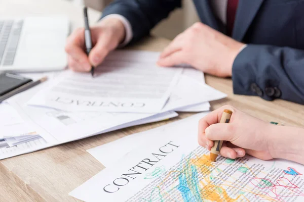Businessman drawing on business papers with son — Stock Photo